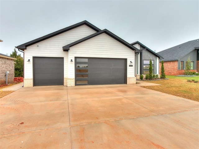 view of front facade featuring concrete driveway, brick siding, and an attached garage