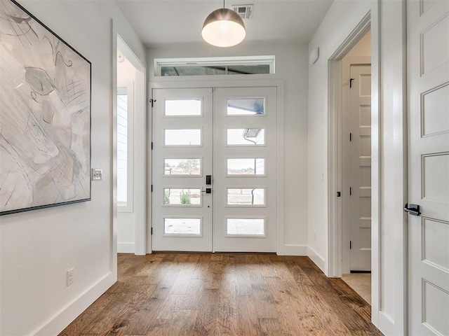 entryway with french doors, visible vents, baseboards, and wood finished floors