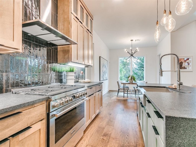 kitchen featuring light wood-type flooring, wall chimney exhaust hood, stainless steel range, and backsplash