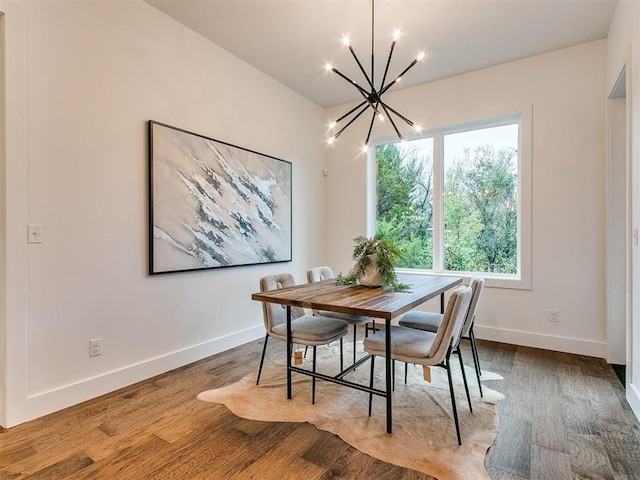 dining space featuring an inviting chandelier, baseboards, and wood finished floors