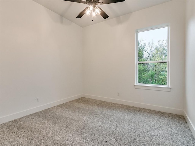 carpeted spare room featuring ceiling fan and baseboards