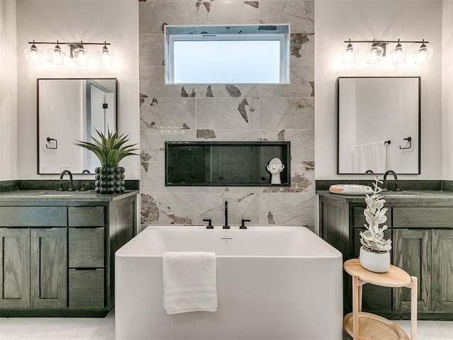 full bath with two vanities, a soaking tub, a sink, and tile walls