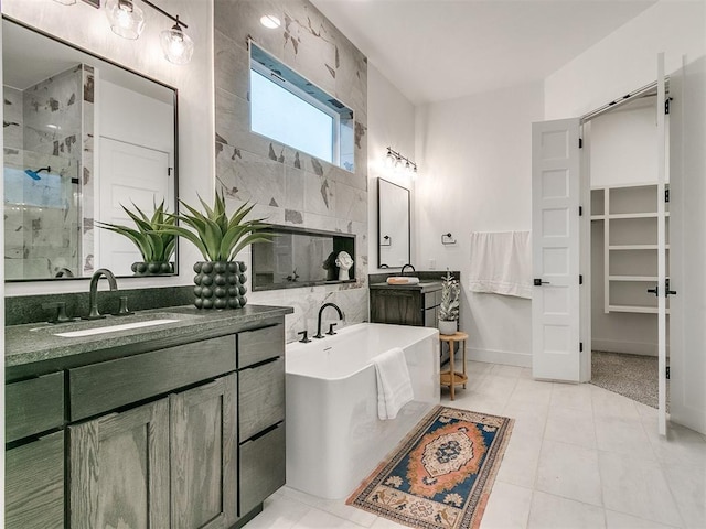 full bath with two vanities, a sink, a freestanding bath, tile patterned floors, and a stall shower