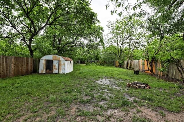 view of yard featuring a fenced backyard, a storage unit, and an outdoor structure