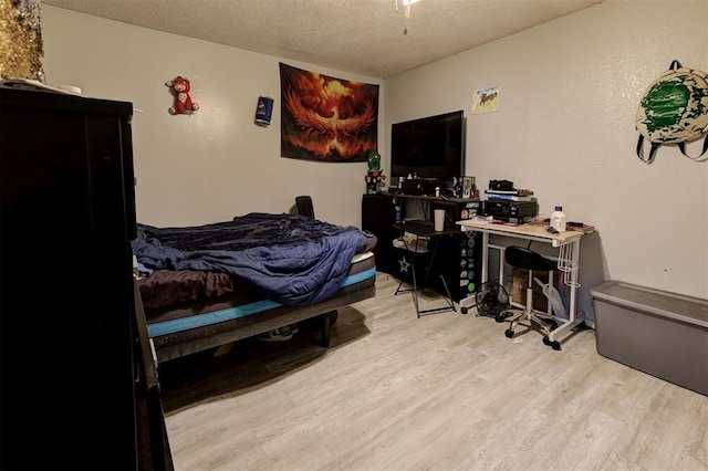 bedroom with a textured ceiling and wood finished floors