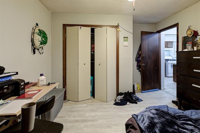 bedroom featuring a textured ceiling, light wood-style flooring, and a closet
