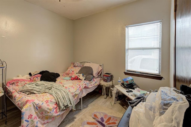 bedroom featuring multiple windows and wood finished floors