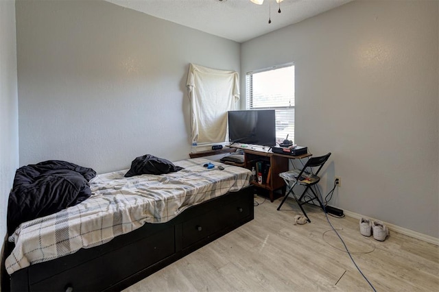 bedroom featuring baseboards and wood finished floors