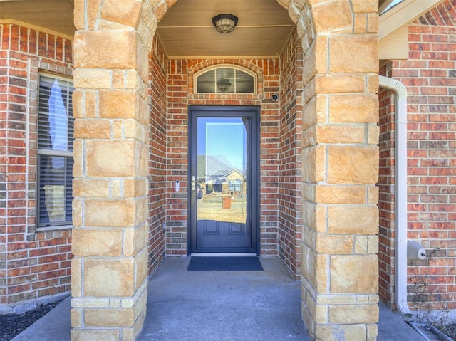 view of exterior entry with brick siding