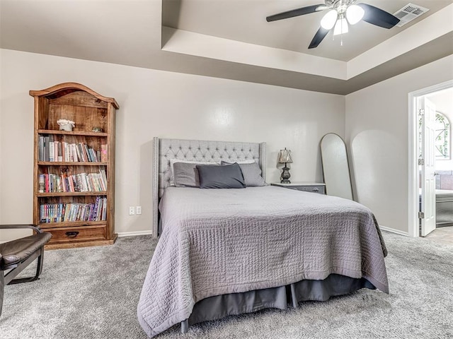 bedroom featuring baseboards, visible vents, a tray ceiling, and carpet flooring