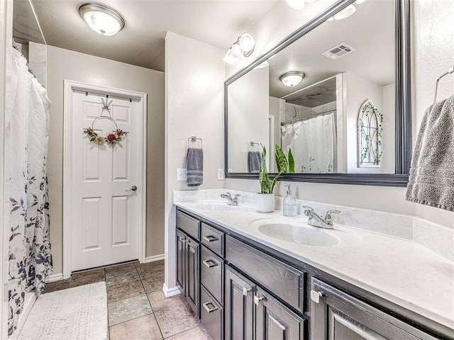 bathroom with visible vents, a sink, baseboards, and double vanity