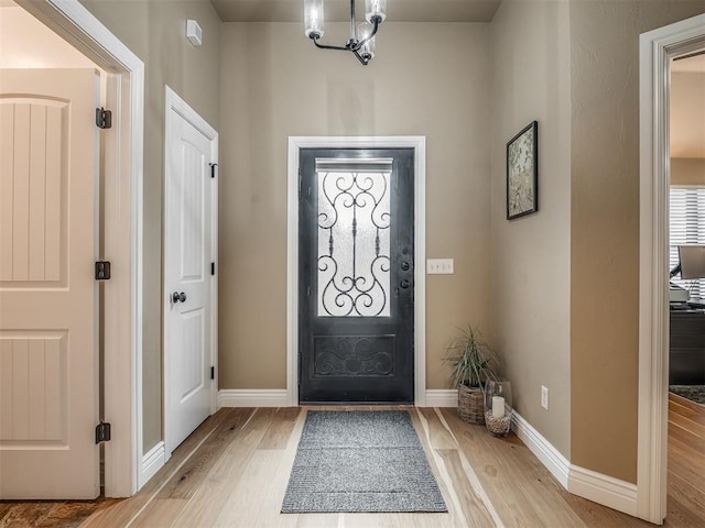 entryway with light wood finished floors and baseboards