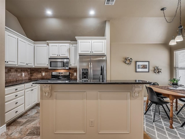 kitchen with a center island, decorative light fixtures, decorative backsplash, stainless steel appliances, and white cabinetry