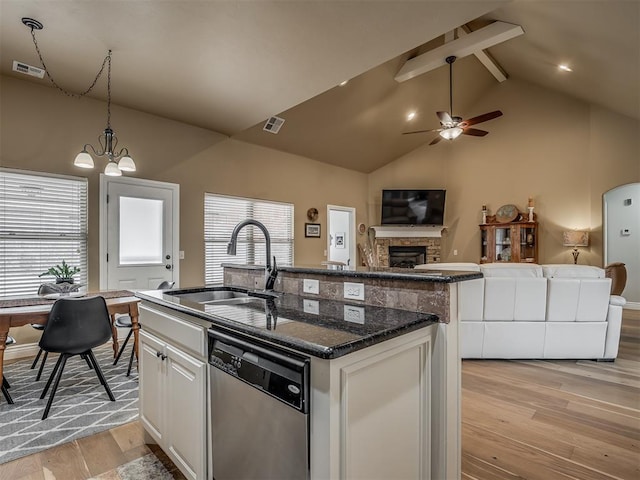 kitchen featuring visible vents, an island with sink, ceiling fan with notable chandelier, a sink, and dishwasher