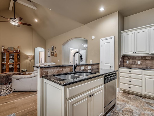 kitchen with a ceiling fan, arched walkways, a sink, stainless steel dishwasher, and open floor plan