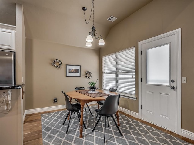 dining area with baseboards, lofted ceiling, and dark wood-style flooring