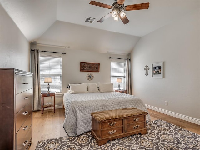 bedroom featuring visible vents, lofted ceiling, baseboards, and light wood-style flooring