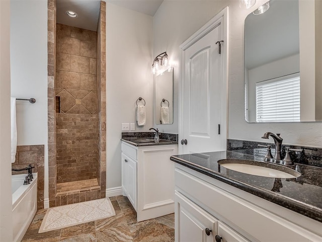 full bathroom with a sink, a garden tub, two vanities, and a walk in shower