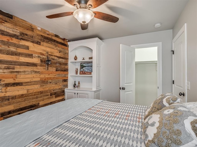 bedroom with wood walls and a ceiling fan