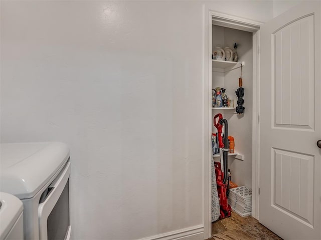 washroom with stone finish floor and washing machine and clothes dryer