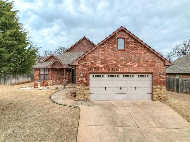 view of front of property with fence, an attached garage, a shingled roof, concrete driveway, and brick siding