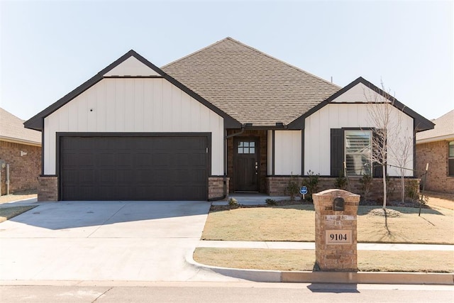 modern farmhouse featuring roof with shingles, brick siding, concrete driveway, board and batten siding, and a garage