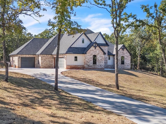 view of front of property featuring roof with shingles, brick siding, board and batten siding, a garage, and driveway