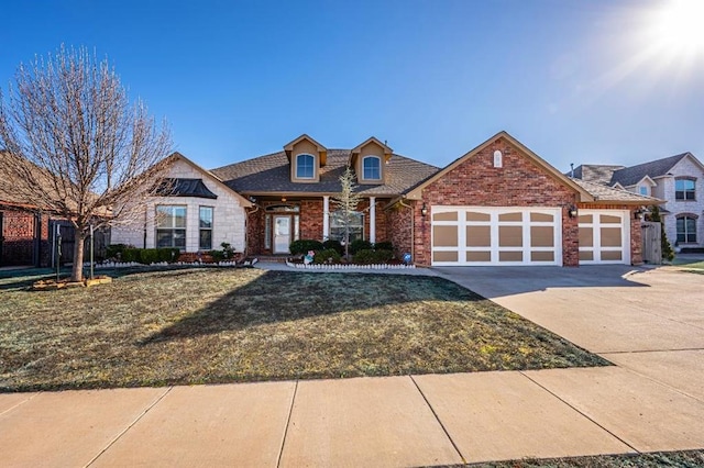 view of front of property featuring a garage, driveway, brick siding, and a front yard