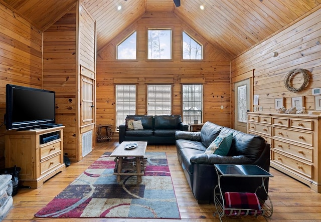 living area featuring wooden ceiling, light wood-type flooring, wood walls, and high vaulted ceiling