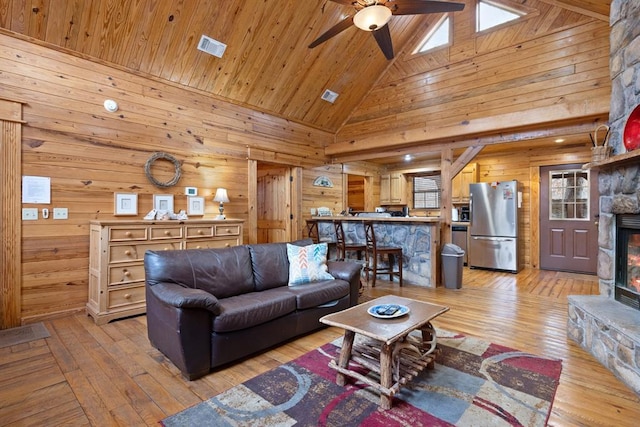 living room featuring wooden ceiling, wooden walls, light wood-style flooring, and visible vents