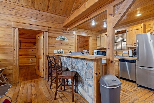 kitchen featuring appliances with stainless steel finishes, wood ceiling, light wood-type flooring, and a kitchen breakfast bar