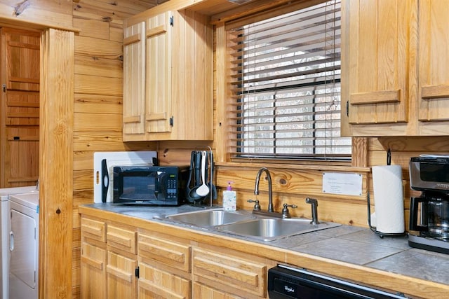 kitchen featuring light brown cabinetry, a sink, tile counters, dishwasher, and washing machine and dryer