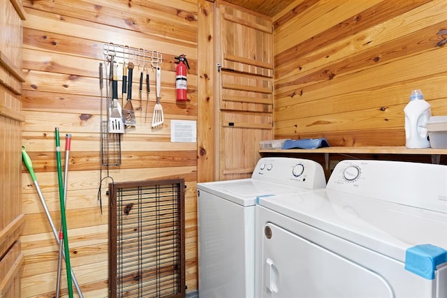 laundry room featuring washer and clothes dryer, laundry area, and wood walls