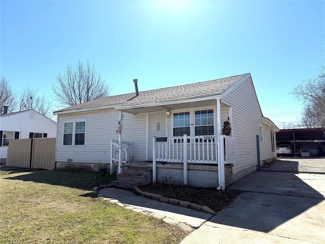 ranch-style home with a porch, a front yard, and concrete driveway