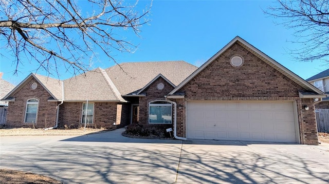 view of front of property with a garage, concrete driveway, brick siding, and a shingled roof