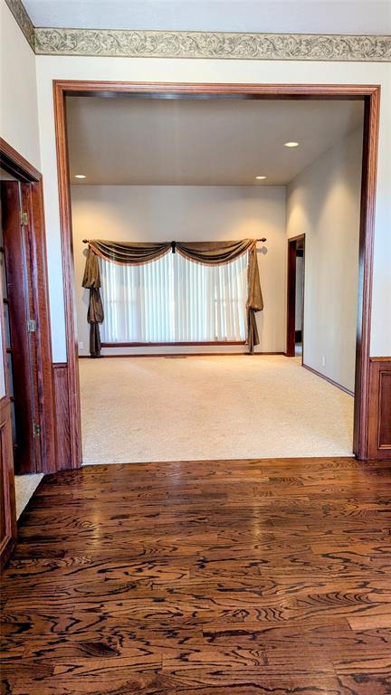 empty room featuring dark carpet and dark wood-style flooring