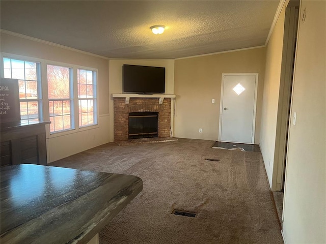 unfurnished living room featuring ornamental molding, carpet, a brick fireplace, and a textured ceiling