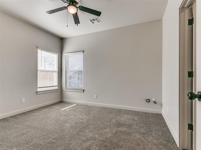 spare room with baseboards, visible vents, ceiling fan, and carpet flooring