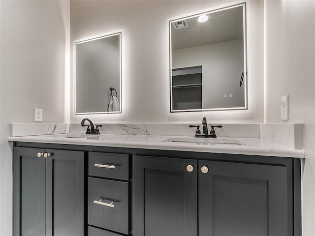 full bath with visible vents, a sink, and double vanity