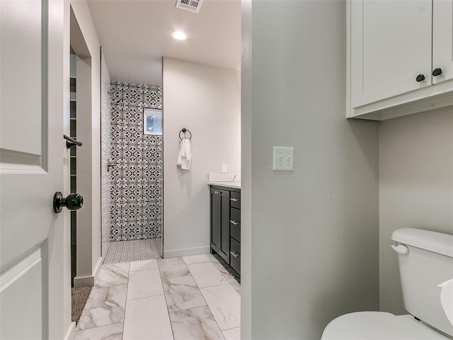 bathroom with visible vents, tiled shower, toilet, marble finish floor, and vanity