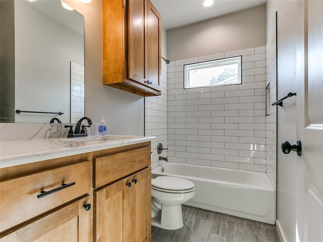 bathroom featuring washtub / shower combination, vanity, toilet, and wood finished floors