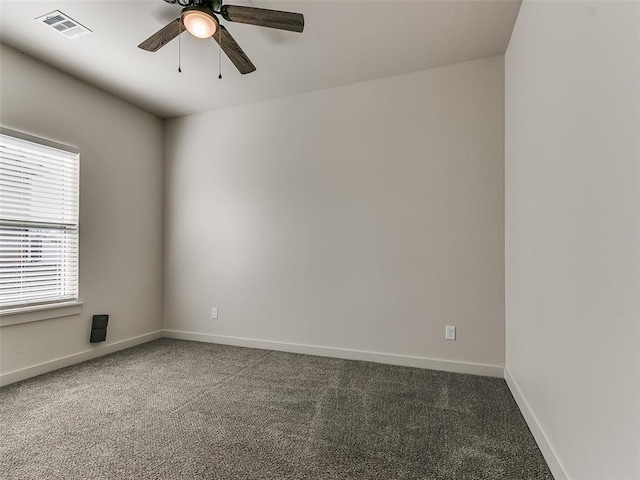 carpeted empty room with visible vents, ceiling fan, and baseboards