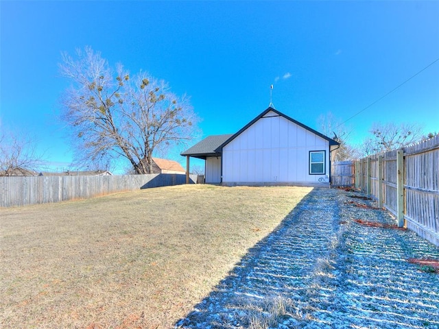 view of home's exterior featuring a yard, board and batten siding, and a fenced backyard