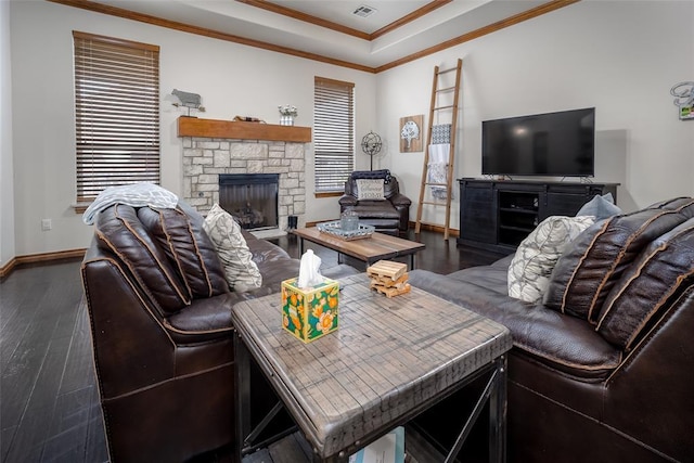 living area with crown molding, a stone fireplace, wood finished floors, plenty of natural light, and baseboards