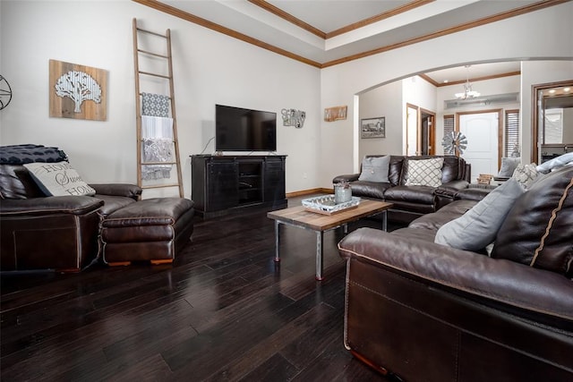 living area featuring arched walkways, a notable chandelier, dark wood finished floors, ornamental molding, and baseboards