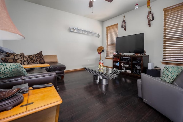 living room with a ceiling fan, baseboards, and wood finished floors