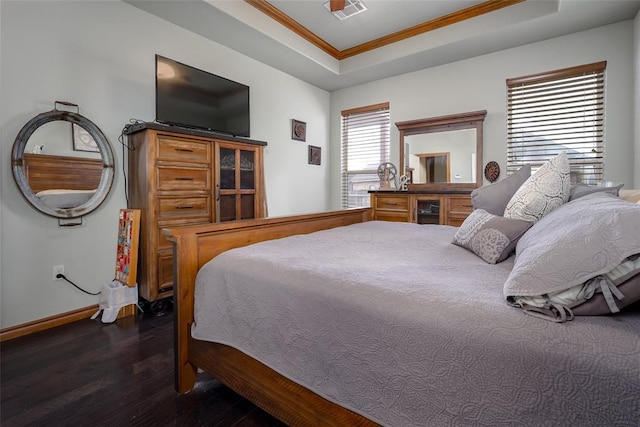 bedroom featuring crown molding, a raised ceiling, visible vents, wood finished floors, and baseboards