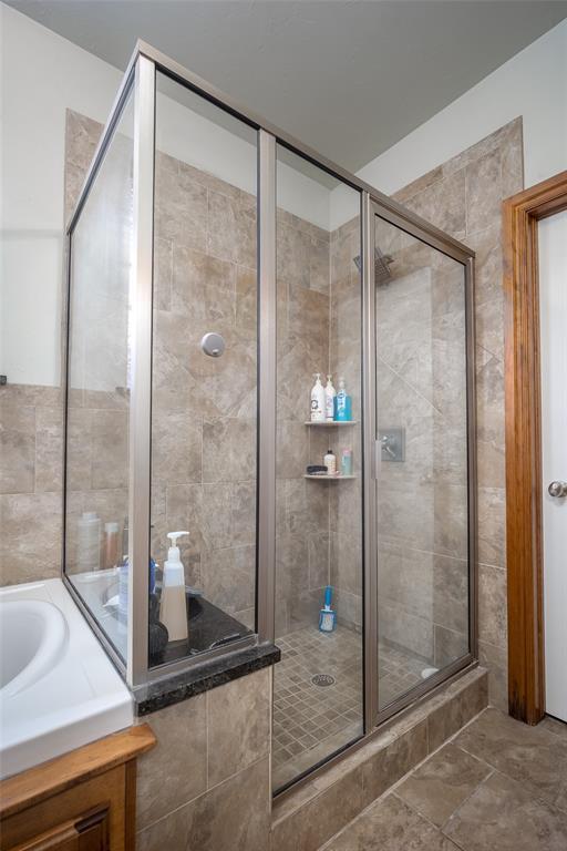 bathroom featuring a stall shower and a bath