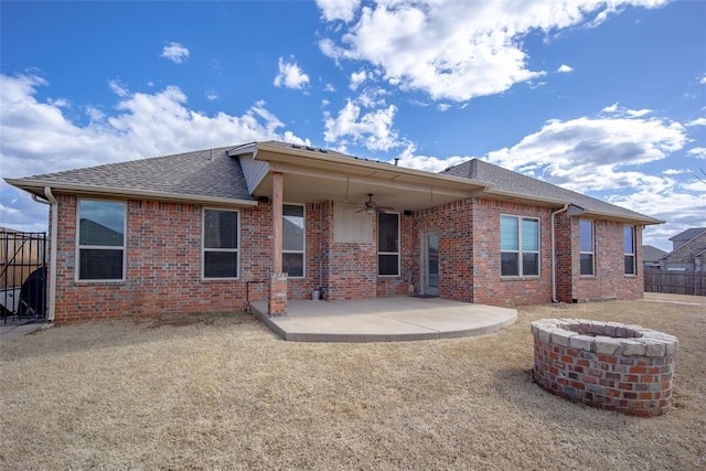 rear view of house with ceiling fan, brick siding, a shingled roof, fence, and a patio area