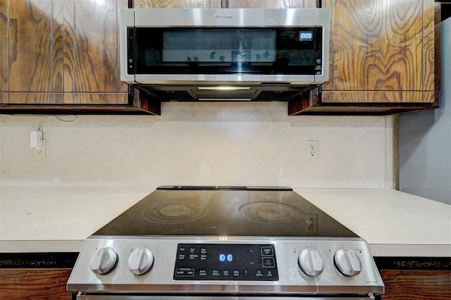 kitchen featuring light countertops, brown cabinetry, and appliances with stainless steel finishes